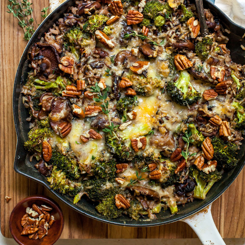 Overhead view of wild rice and cheesy broccoli casserole in a skillet.