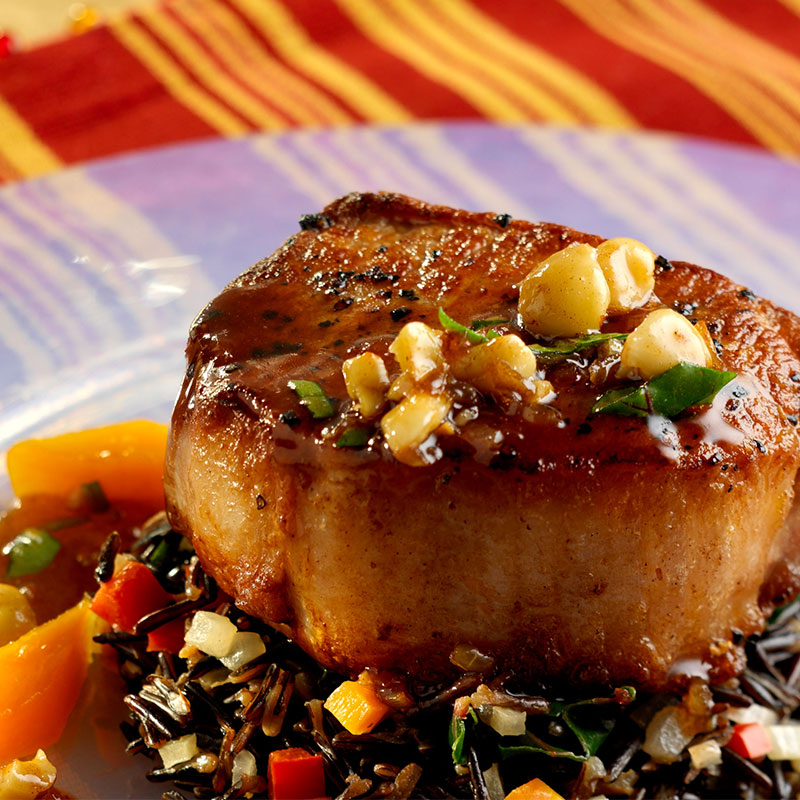 Close up view of pork and wild rice chili on a clear plate.