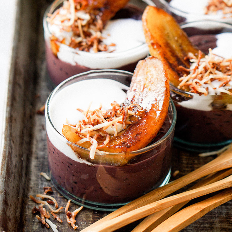 Side view of purple rice coconut pudding in single serve glass dishes.