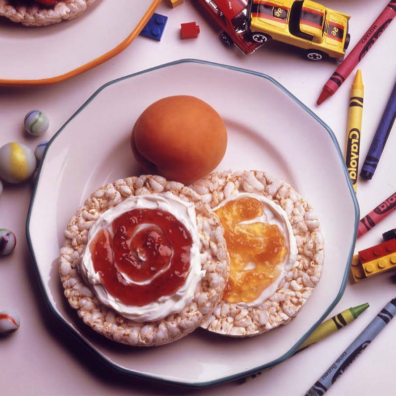 Two Rice Cake Delights on a plate with a peach to the side.