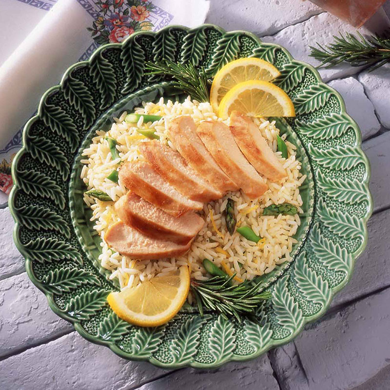 Overhead view of rosemary chicken with asparagus lemon rice on a green plate.