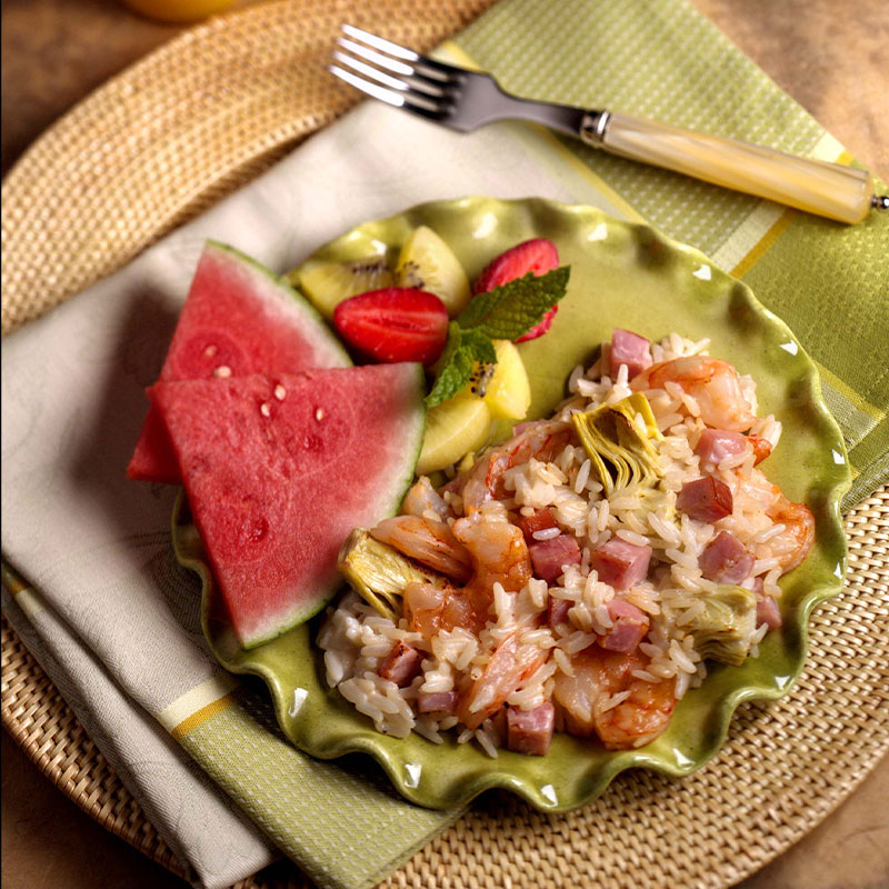 Overhead shot of a serving of Shrimpy Rice Brunch Bake with sides of watermelon and strawberries.