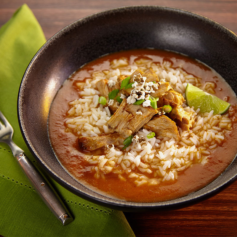 Overhead view of socal pork caldra in a black ceramic bowl.