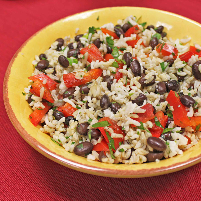 Side view of southwest black bean and brown rice salad in a yellow bowl.