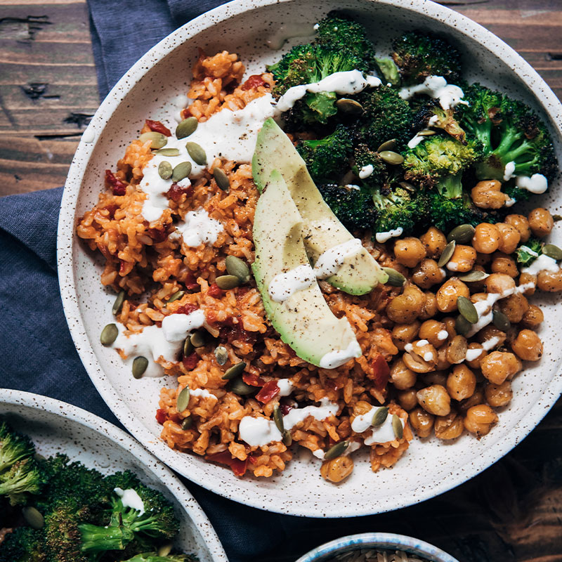 Overhead shot of a Spicy Vegan Brown Rice Bowl with dressing drizzled on top.