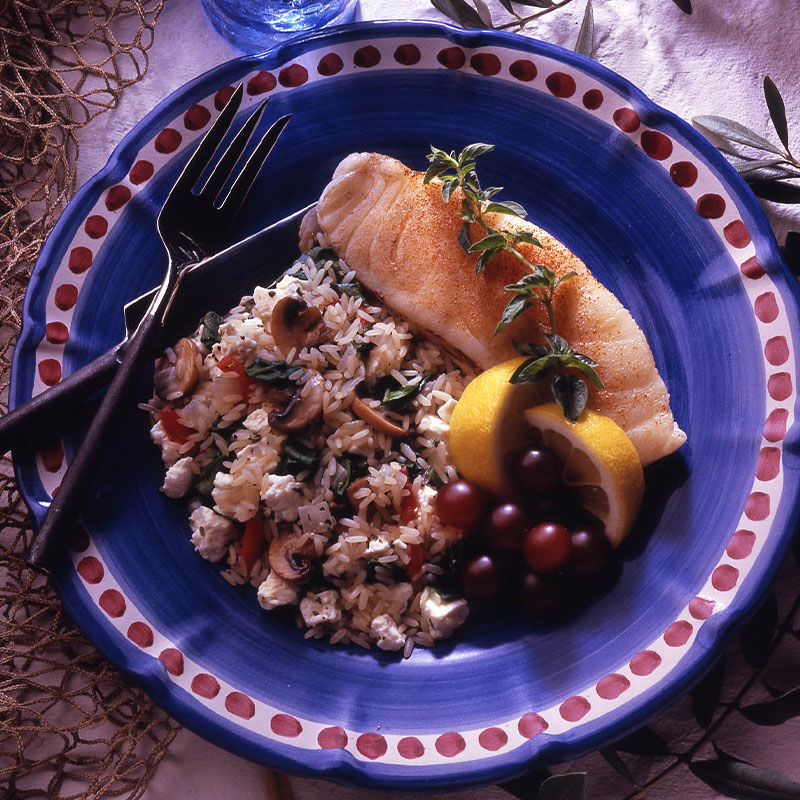 Overhead image of Spinach Feta Rice paired with a fish fillet on a blue plate.