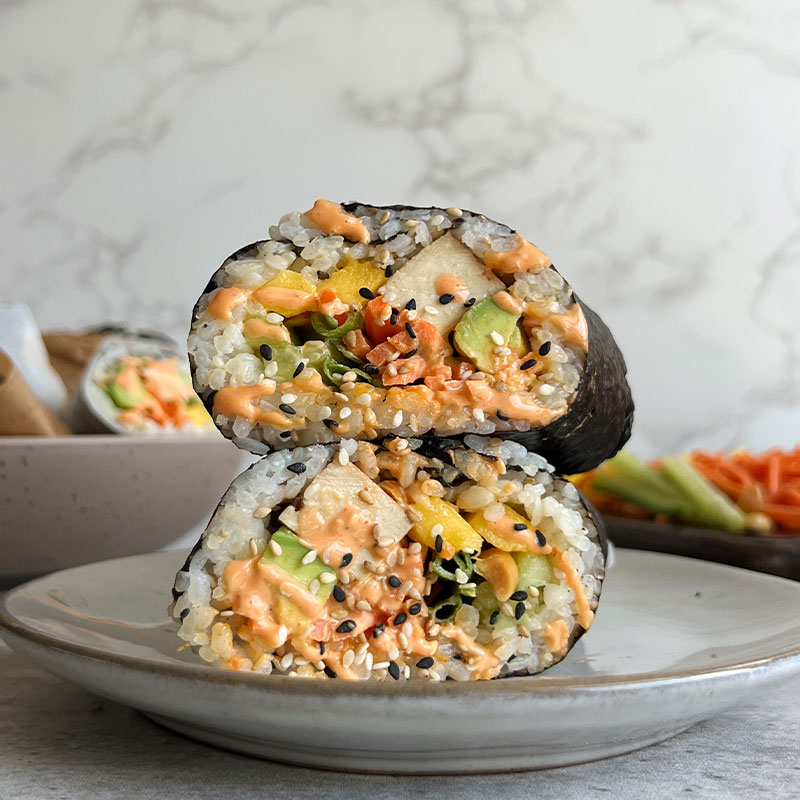 Sliced sushi burrito on top of one another.