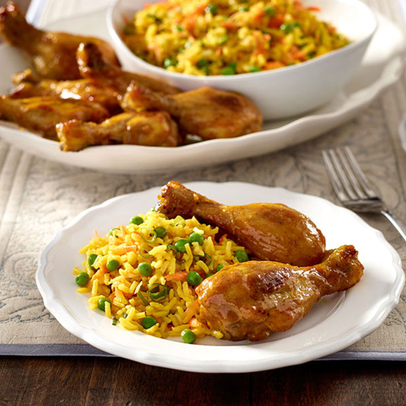 A side view of a serving of Sweet Curry Drumsticks with Basmati Pilaf.