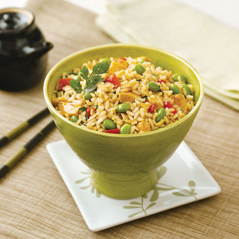 One Teriyaki Chicken & Edamame Rice Bowl in a green bowl with chopsticks to the side.