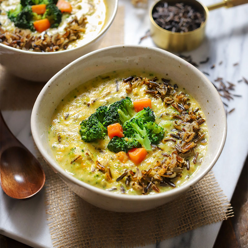 Serving of Vegan Broccoli, Cheese & Wild Rice Soup in a white bowl.