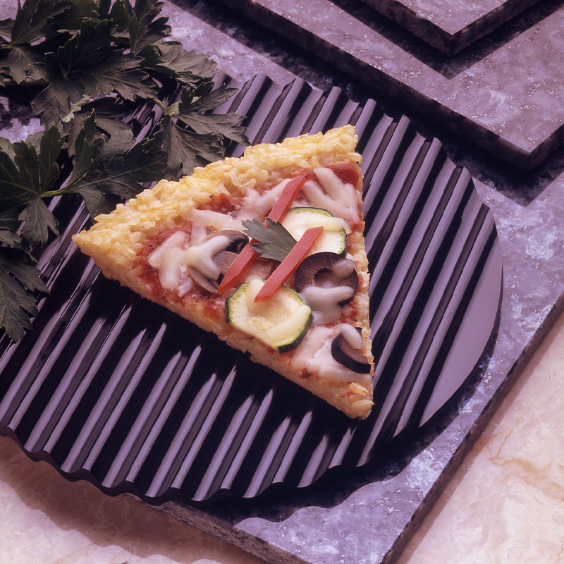 Overhead shot of a single slice of vegetable rice pizza where rice grains can be spotted in the crust.