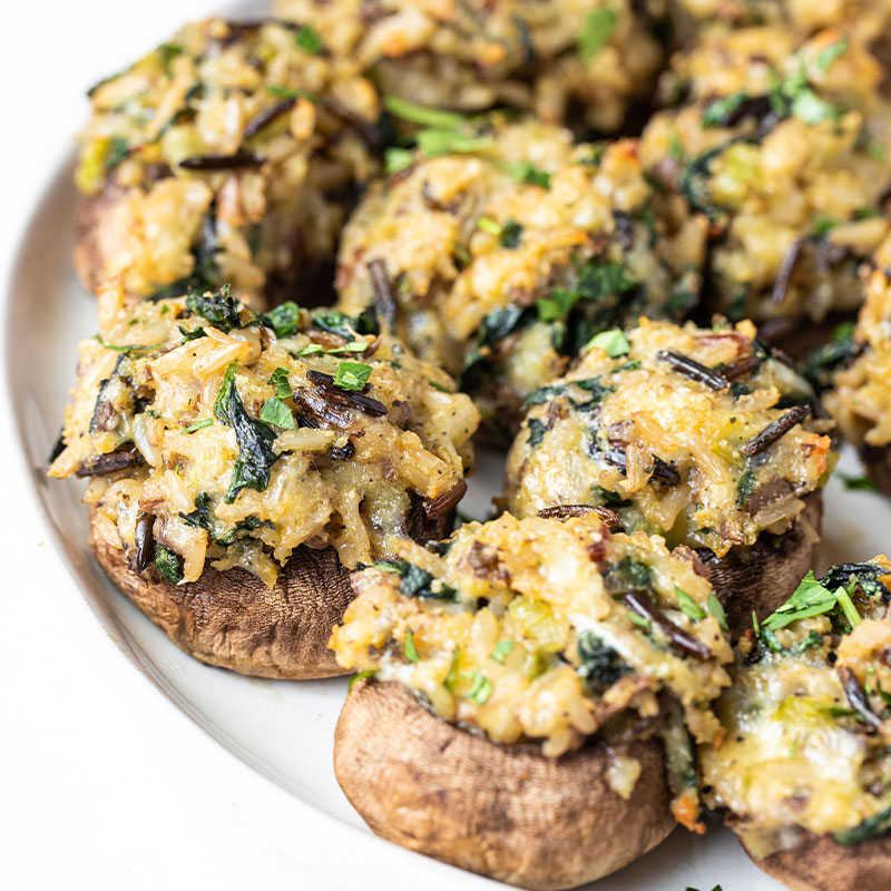 Side view of a platter of little wild rice stuffed mushrooms.