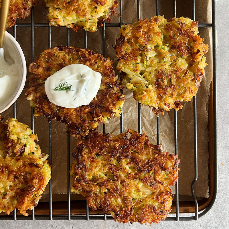 Overhead view of veggie rice fritters on a cooking tray.