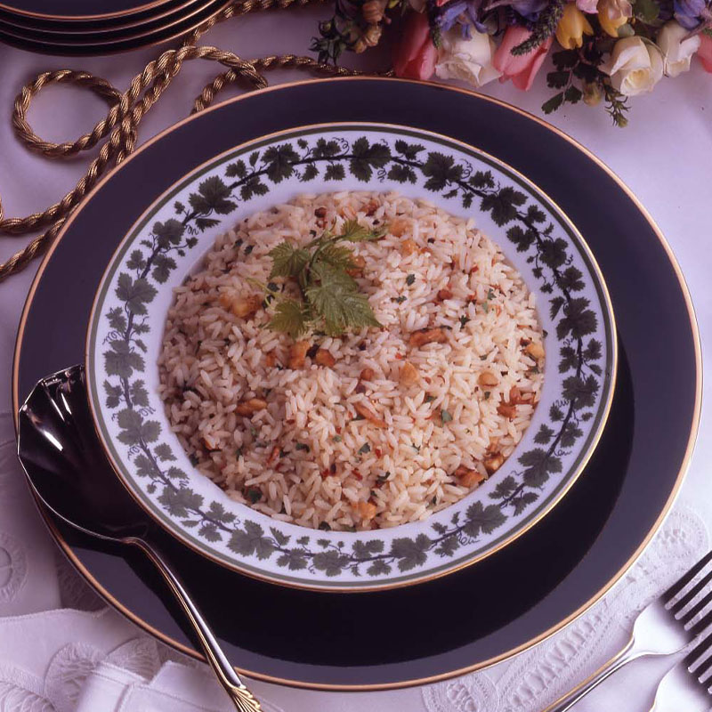 Overhead shot of a large serving of white rice with walnuts sprinkled throughout and topped with parsley.