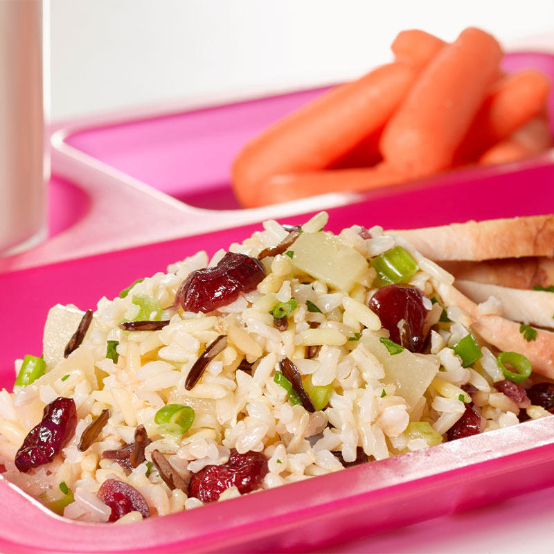 A serving of Wild & Brown Rice salad on a pink cafeteria tray.