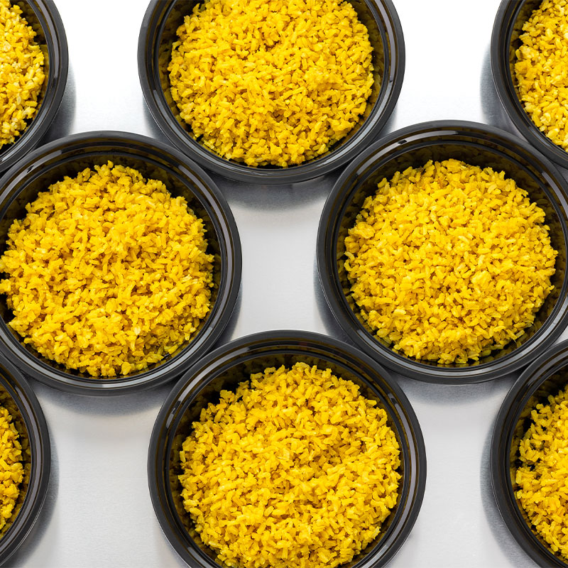 Overhead image of multiple bowls of yellow rice.