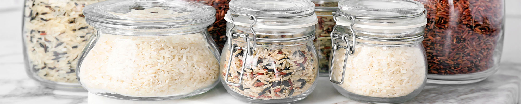 5 jars of various shape and size holding different types of rice.