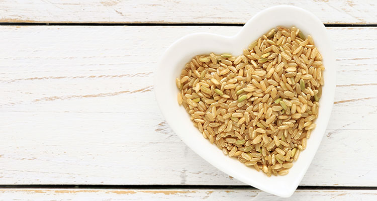 Overhead view of a heart-shaped bowl filled with brown rice.