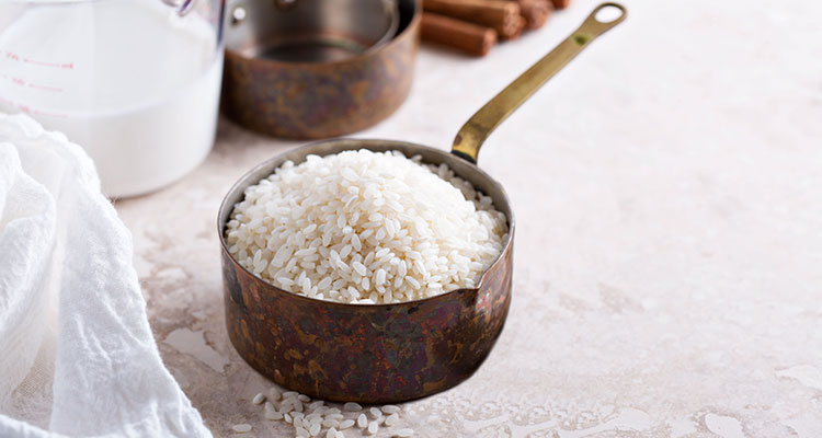 Side view of a measuring cup filled with rice grains.