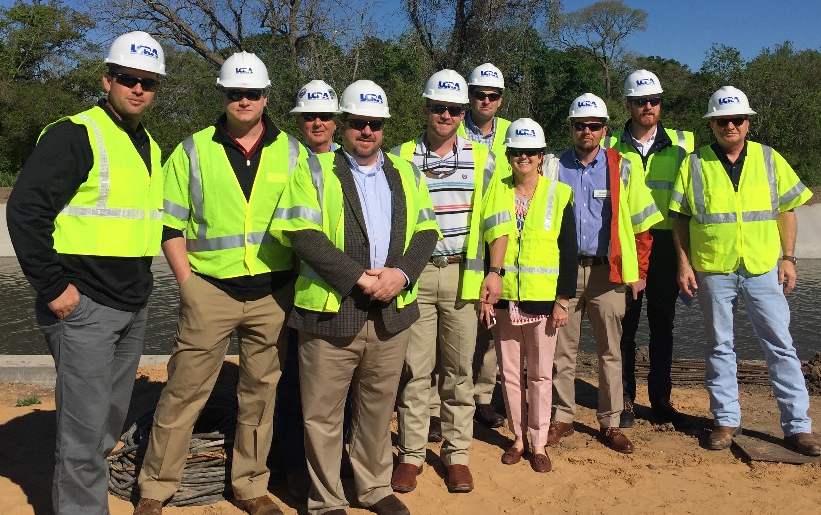 Group shot of people wearing fluorescent vests and hard hats at Arbuckle Reservoir TX