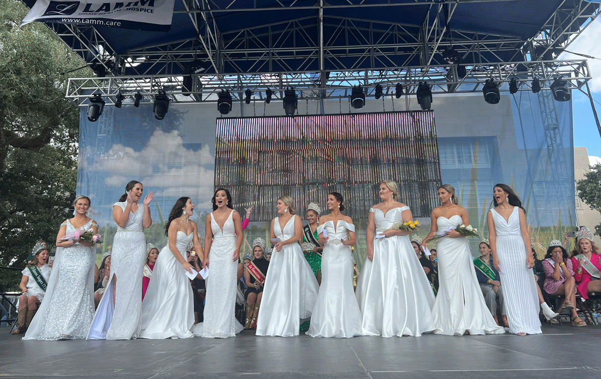 85th-IRF-Queen-Announcement, line up of women in formal white dresses stading on event stage