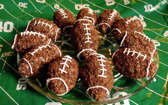 Cocoa Krispies football treats on a glass plate on top of a green tablecloth with yardage lines