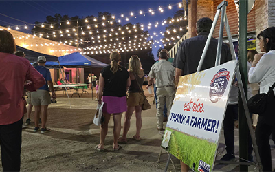 Delta Fest, Thank A Farmer sign, crowd stands under strings of white lights