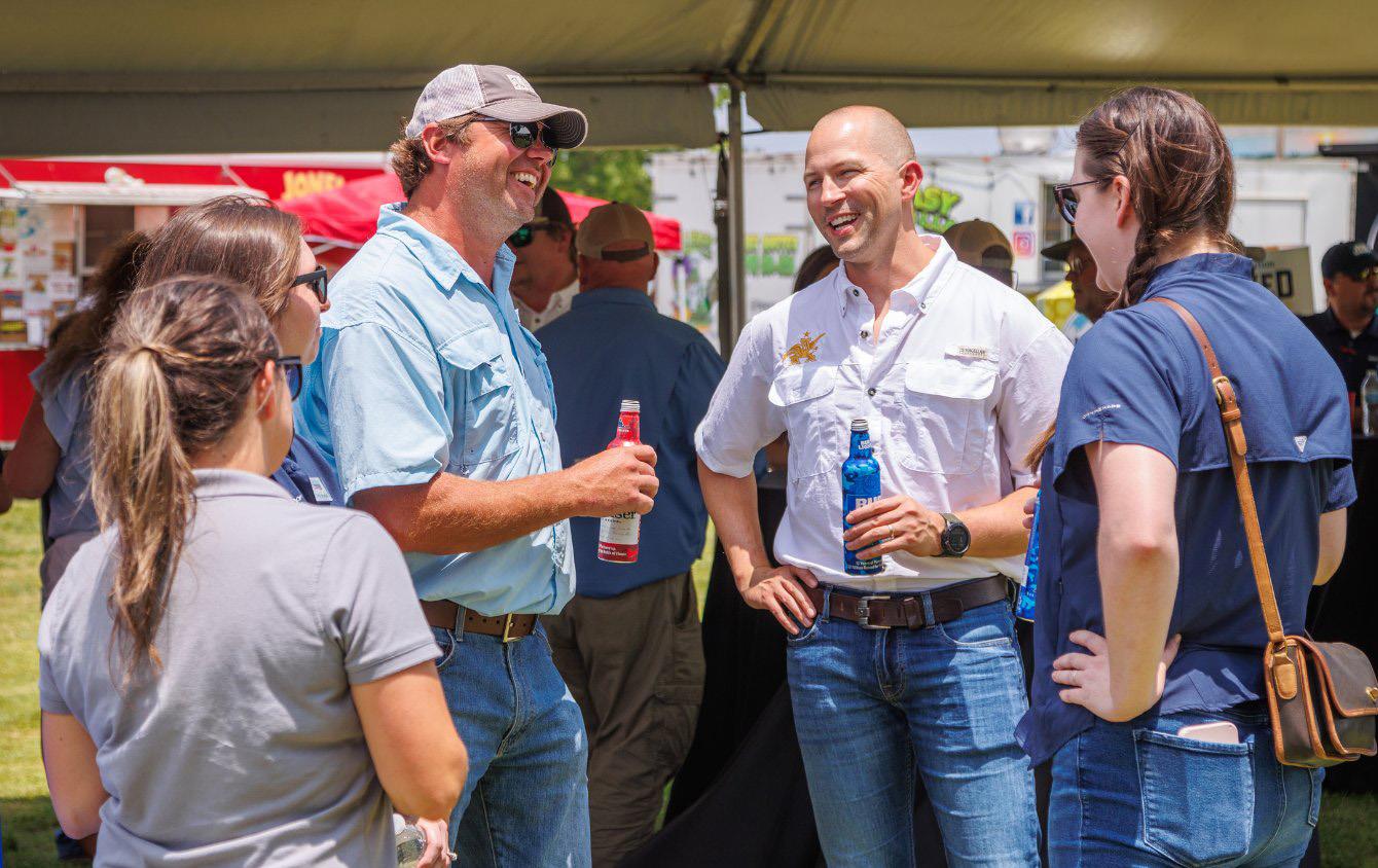 Candid photo of casually dressed people, talking and drinking beer