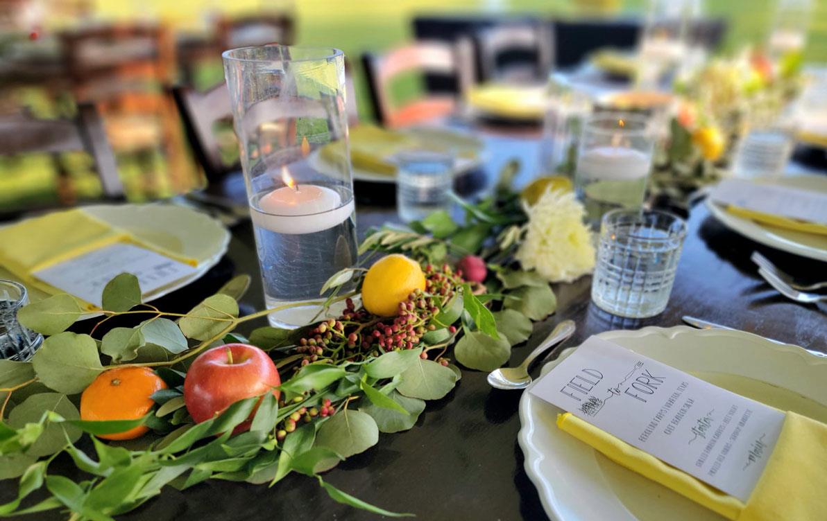 TX-Field-to-Fork-table-setting with candles, greenery, & fruit centerpieces