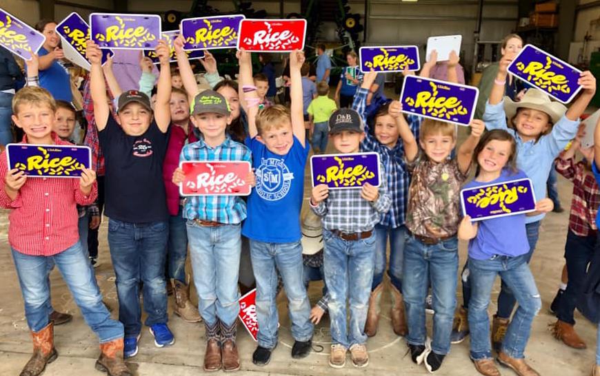 Group of children holding RICE license plates