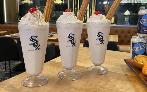 Three horchata shakes in White Sox parfait glasses with cherries on top