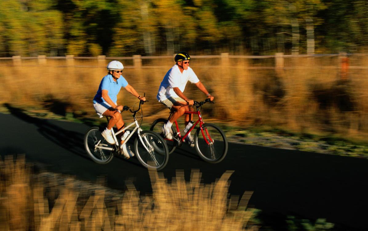 Older white couple riding-bikes