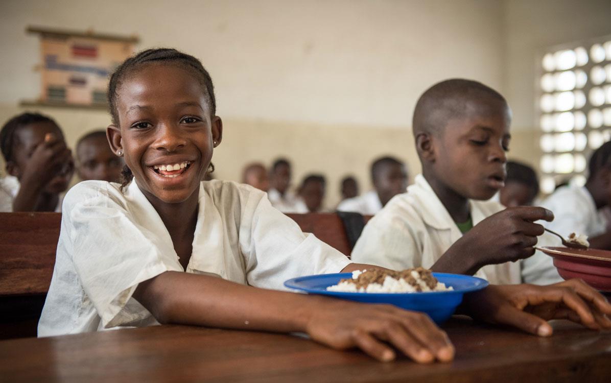 Children in classroom in Sierra Leone eating-fortified-rice