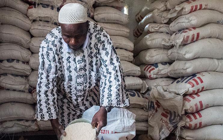 Man-pouring-fortified-rice-from-bag-into-bucket,-M.-Stuhlman-photo