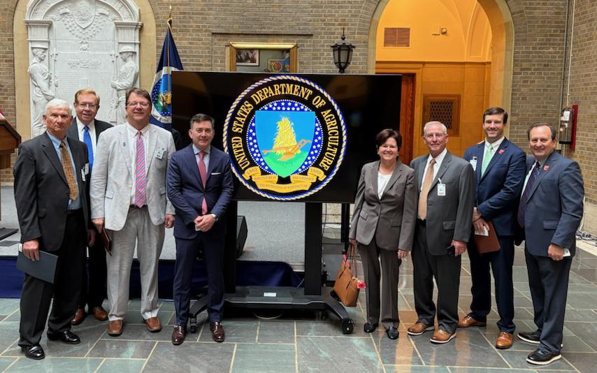 Group shot of USA Rice members standing around USDA logo