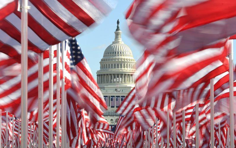 Field of waving American flags framing US Capitol dome