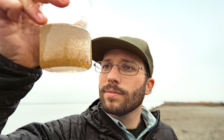 Man holds jar of plankton from CA Rice Fields 