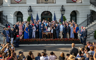 Trump Signs Big Beautiful Bill at White House ceremony with legislators and bank of photographers