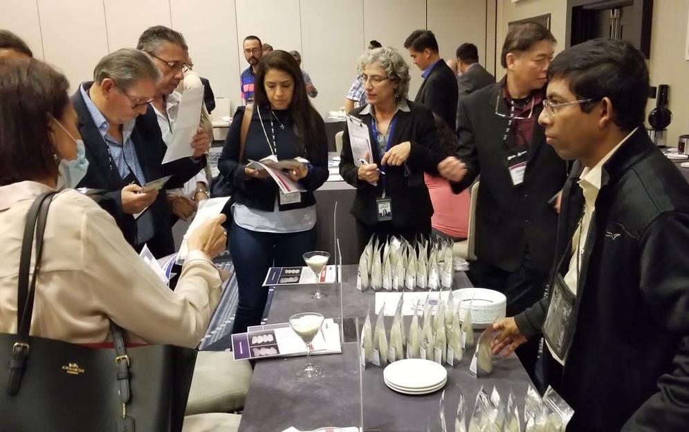 People crowded around table-filled with-rice samples