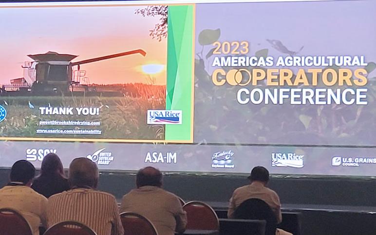 2023-Americas-Agricultural-Cooperators-Conference,-long-shot, projection screen w/photo of combine