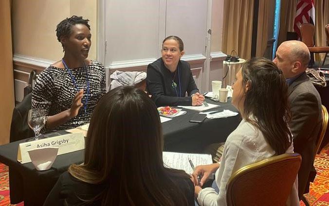 A.-Grigsby(left) seated at table with three potential customers during "speed dating" session of Costa-Rica-mtg