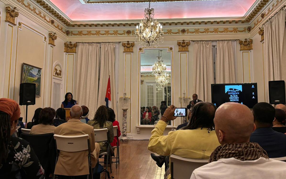 Black-History-Celebration-at-Cuban-Embassy shows speaker at podium & audience in ballroom