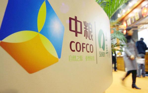 COFCO-sign-in-shopping-mall, woman walking by and plants in background