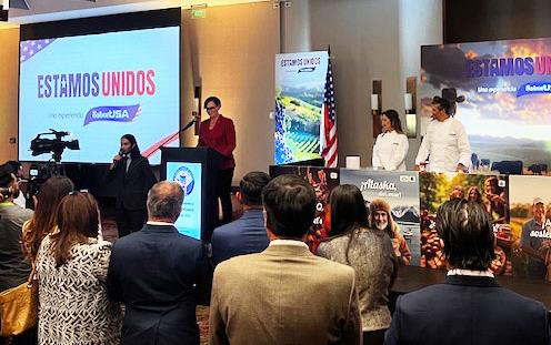 Estamos-Unidos-presentation at Colombia trade mission, people on stage surrounded by large photos of farms, food, and flags