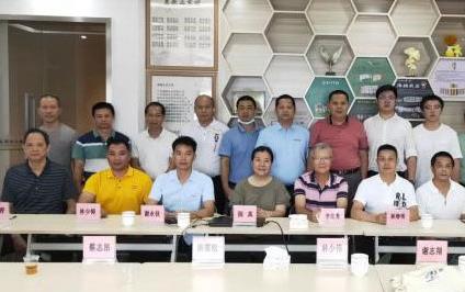 Group shot of Asian people sitting and standing in front of backdrop made of hexagons