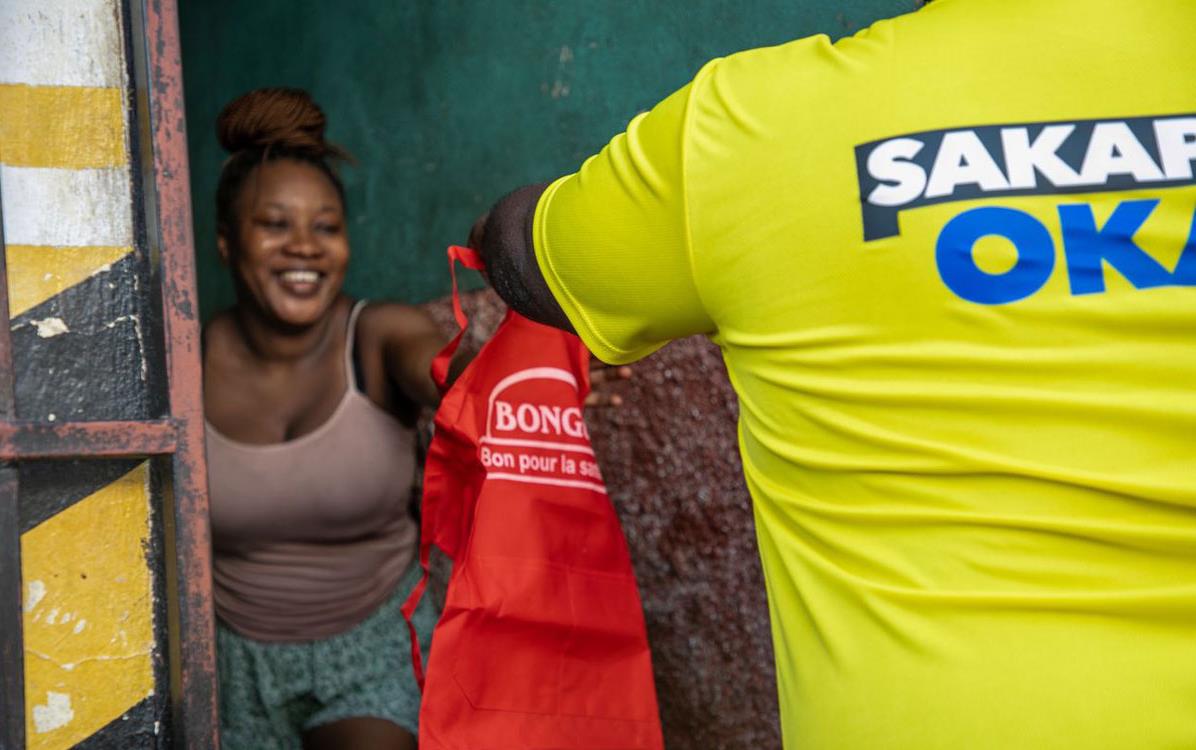 Man-delivers-Bongo-apron to woman in Cap-Haitien