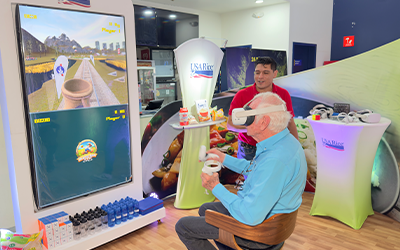 Older man seated in chair in front of screen playing Harvest Rush VR game