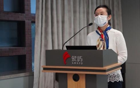 Woman wearing medical mask stands at podium