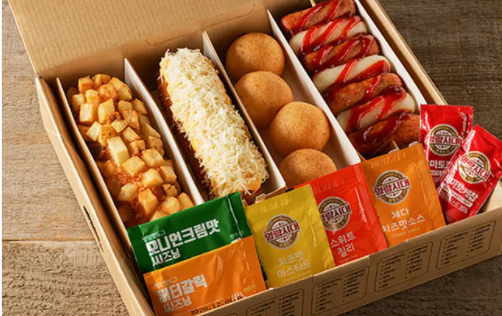Box of corn dogs with packets of sauce