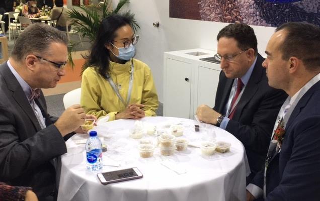 Three men and one woman sit around table filled with rice samples